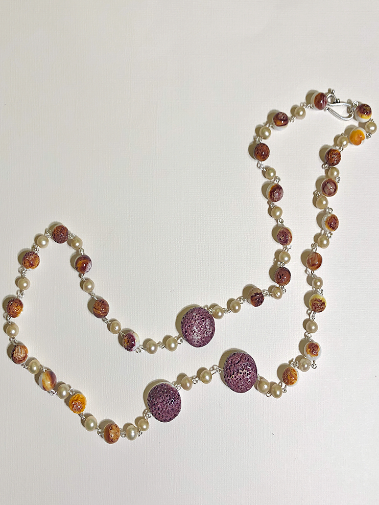 A long necklace featuring spiny oyster shell and Swarovski pearls, linked together with silver connectors.