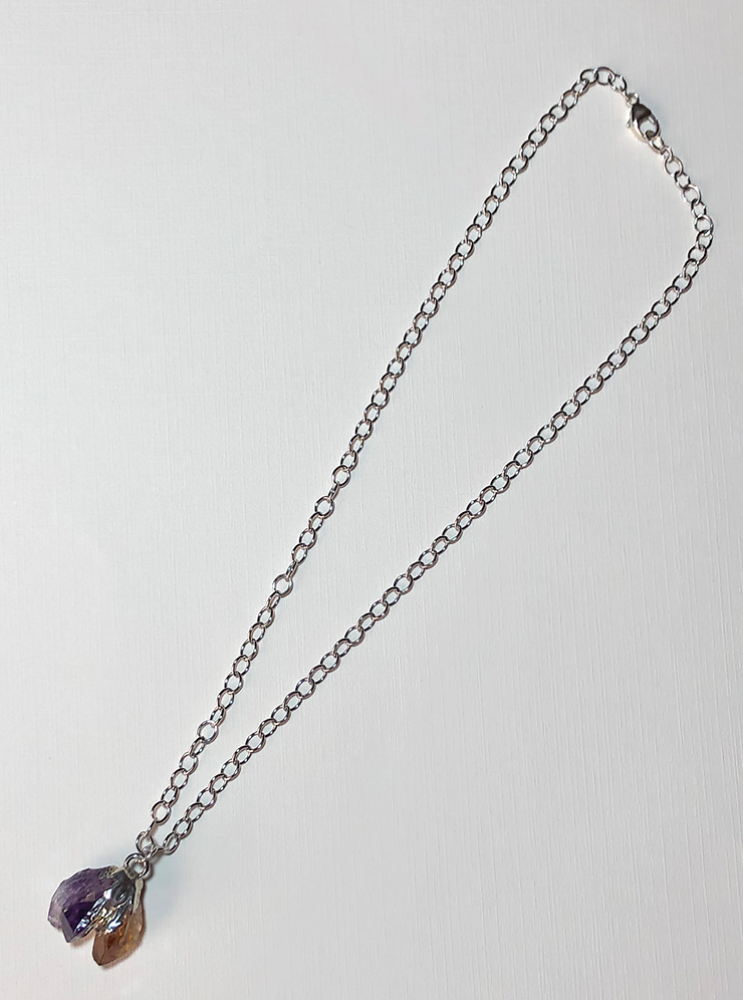 Pendant featuring natural amethyst and citrine set in silver and suspended on a sterling silver chain.